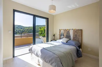 a bedroom with a bed and a large window at Villa Oia - avec piscine privée in Conca