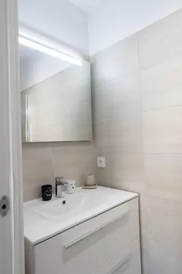a bathroom with a white sink and a mirror at Villa Oia - avec piscine privée in Conca