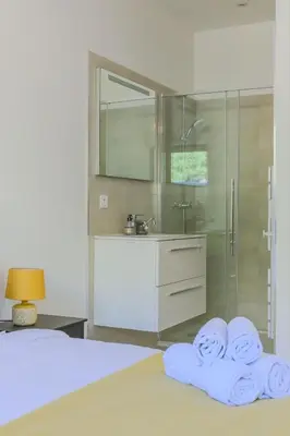 a bathroom with a shower and two towels on a bed at Villa Oia - avec piscine privée in Conca