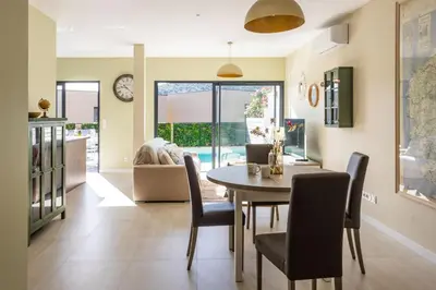 a dining room and living room with a table and chairs at Villa Oia - avec piscine privée in Conca