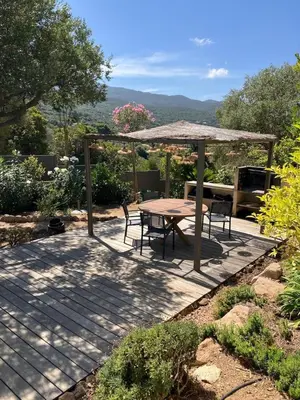 a patio with a table and chairs and an umbrella at Large Family Villa, exceptional sea view in Coti-Chiavari