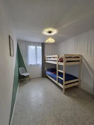 a bedroom with two bunk beds and a chair at Quiet flat in Ajaccio neat beaches and downtown in Ajaccio