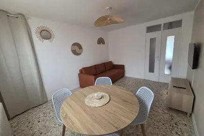 a living room with a table and a couch at Quiet flat in Ajaccio neat beaches and downtown in Ajaccio