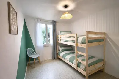 a bedroom with a bed with an orange wall at Quiet flat in Ajaccio neat beaches and downtown in Ajaccio