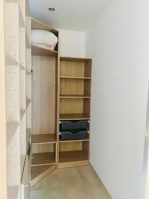a walk in closet with wooden cabinets and shelves at Villa Piscine Mer 7 min Vue Montagne Clim in Prunelli-di-Fiumorbo