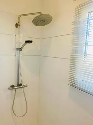 a shower with a shower head in a bathroom at Villa Piscine Mer 7 min Vue Montagne Clim in Prunelli-di-Fiumorbo