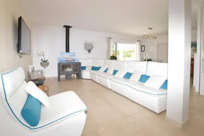 a living room with white chairs and a fireplace at Villa Piscine Mer 7 min Vue Montagne Clim in Prunelli-di-Fiumorbo