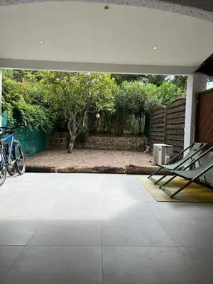 a view of a patio with a table and a bike at Appartement T2 jardin & accès plage privée in Grosseto-Prugna