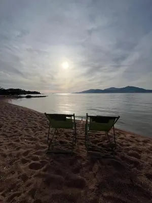 two beach chairs sitting on the sand on a beach at Appartement T2 jardin & accès plage privée in Grosseto-Prugna