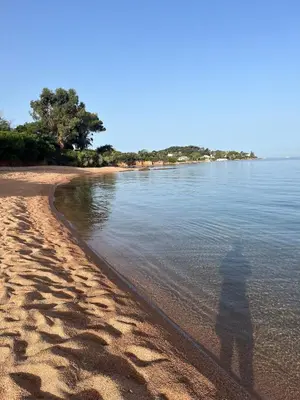 a shadow of a person standing on a beach at Appartement T2 jardin & accès plage privée in Grosseto-Prugna