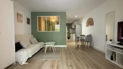a living room with a couch and a table at Appartement T2 jardin & accès plage privée in Grosseto-Prugna