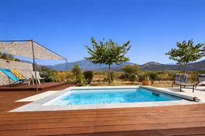 a swimming pool on a deck with a view of mountains at Villa Pietralba - Piscine privée & vue montagne - Proche Calvi in Calenzana