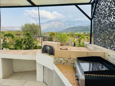 a hot tub on a patio with mountains in the background at Villa Pietralba - Piscine privée & vue montagne - Proche Calvi in Calenzana