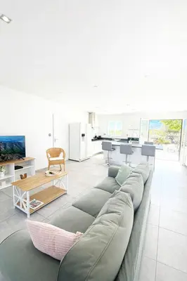 a living room with a couch and a table at Villa Pietralba - Piscine privée & vue montagne - Proche Calvi in Calenzana