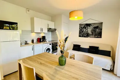 a kitchen and a living room with a table in a room at Mini-villa dans résidence avec piscine T2 BONIFACIO in Bonifacio