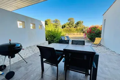 a patio with a table and chairs and a grill at Mini-villa dans résidence avec piscine T2 BONIFACIO in Bonifacio