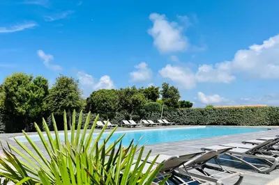 a swimming pool with lounge chairs and a resort at Mini-villa dans résidence avec piscine T2 BONIFACIO in Bonifacio