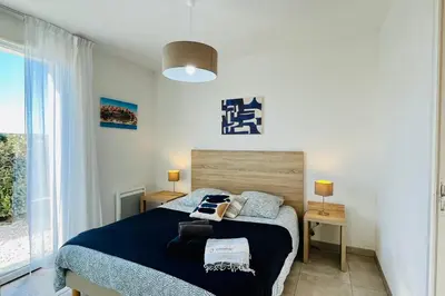 a bedroom with a large bed with blue sheets at Mini-villa dans résidence avec piscine T2 BONIFACIO in Bonifacio