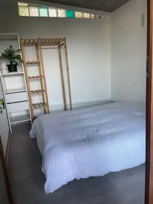 a bedroom with a white bed and a ladder at Famille in Grosseto-Prugna