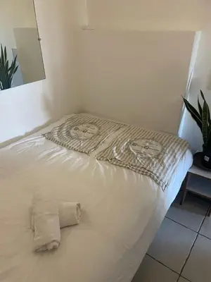 a white bed in a corner of a room at Famille in Grosseto-Prugna