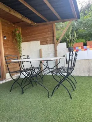 a table and chairs on a patio with grass at Famille in Grosseto-Prugna