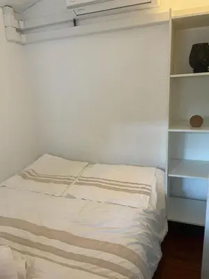 a white bed in a room with a shelf at Famille in Grosseto-Prugna
