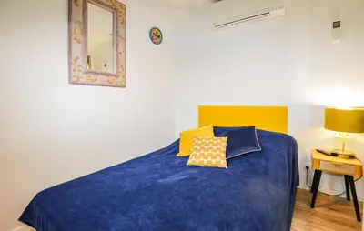 a bedroom with a blue bed with a yellow headboard at Awesome Home In Vero With Private Swimming Pool, Can Be Inside Or Outside in Vero
