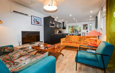 a living room with two blue couches and a tv at Awesome Home In Vero With Private Swimming Pool, Can Be Inside Or Outside in Vero
