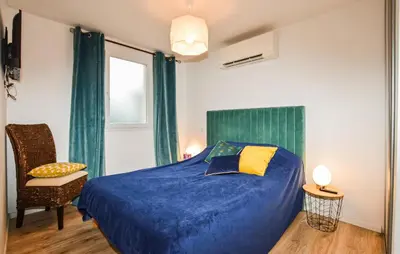 a bedroom with a blue bed with a chair and a window at Awesome Home In Vero With Private Swimming Pool, Can Be Inside Or Outside in Vero