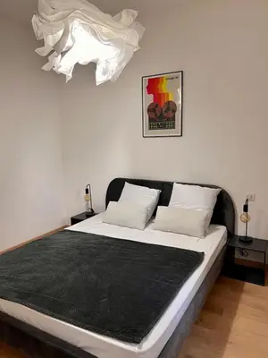a bedroom with a large bed with a black blanket at Village centre appartement in Calenzana