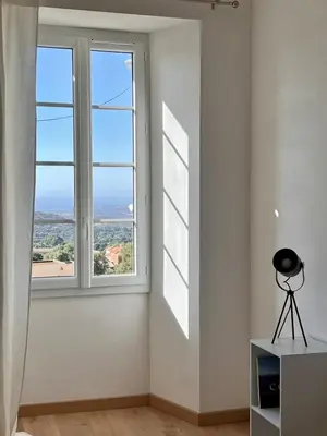 a room with a window with a view of the ocean at Village centre appartement in Calenzana