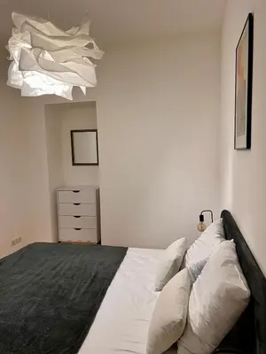 a bedroom with a bed with white sheets and pillows at Village centre appartement in Calenzana