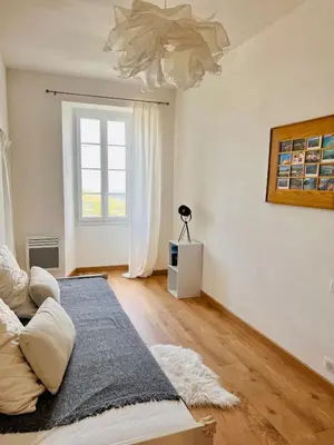 a living room with a bed and a window at Village centre appartement in Calenzana