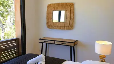 a bedroom with a bed and a table with a mirror at Villa Maria 1. 12 pers, piscine chauffée, 5 min plage in Cirendinu