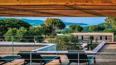 a table and chairs on a balcony with a view at Villa Maria 1. 12 pers, piscine chauffée, 5 min plage in Cirendinu
