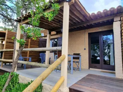 a patio with a wooden fence and a table and chairs at Apartment Ruhe und Entspannung inmitten der Macchia by Interhome in Porto-Vecchio