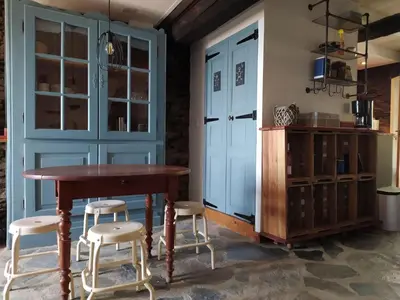 a dining room with a wooden table and stools at Holiday Home Sole e Ventu by Interhome in Velone-Orneto