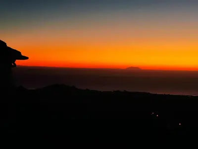a sunset over the ocean with a mountain in the background at Holiday Home Sole e Ventu by Interhome in Velone-Orneto