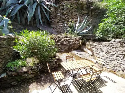 a garden with two benches and a stone wall at Holiday Home Sole e Ventu by Interhome in Velone-Orneto