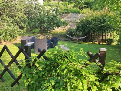 a fence in a garden with a hammock in the yard at Apartment Sole e Ventu 70qm by Interhome in San-Giovanni-di-Moriani