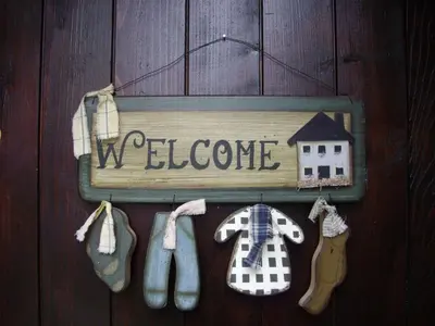 a welcome sign on a door with shoes and a house at Apartment Sole e Ventu 30qm by Interhome in San-Giovanni-di-Moriani