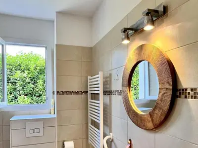 a bathroom with a round mirror and a window at Apartment Résidence Amanda by Interhome in Santa-Lucia-di-Moriani