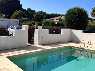 a swimming pool in front of a white fence at Apartment Résidence Amanda by Interhome in Santa-Lucia-di-Moriani