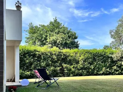 a chair sitting in the grass next to a building at Apartment Résidence Amanda by Interhome in Santa-Lucia-di-Moriani