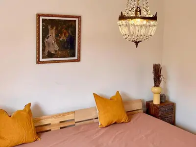 a bedroom with a bed with yellow pillows and a chandelier at Apartment Résidence Amanda by Interhome in Santa-Lucia-di-Moriani