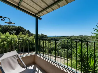 a balcony with a chair and a view at Holiday Home Domaine Punta della Guardia Maison A Figa mit Blick auf das Meer by Interhome in Cervione