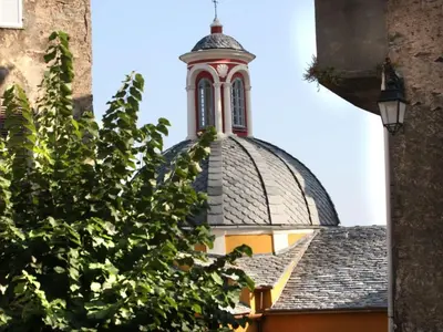 a building with a clock tower on top of it at Holiday Home Weingut Punta della Guardia Ruhig und beschaulich by Interhome in Cervione