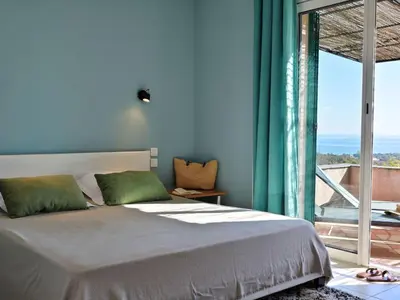 a bedroom with a bed and a large window at Holiday Home Weingut Punta della Guardia Ruhig und beschaulich by Interhome in Cervione