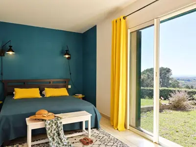a bedroom with a bed and a large window at Holiday Home Weingut Punta della Guardia Ruhig und beschaulich by Interhome in Cervione