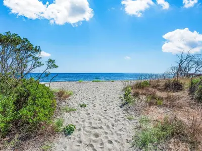 a sandy beach with the ocean in the background at Holiday Home Weingut Punta della guardia zwischen Meer und Gebirge by Interhome in Cervione